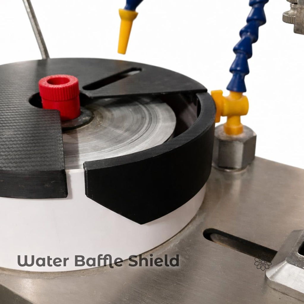 Close-up of a faceting machine basin showing a black water baffle shield installed along the inner edge. On-image text reads “Water Baffle Shield.” The image highlights controlled water flow near the lap and improved splash containment, with the baffle positioned between the lap and the basin wall.