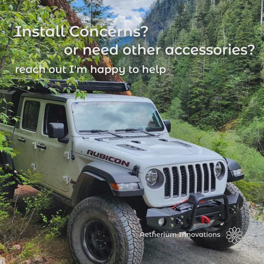 White Jeep Rubicon parked on a forest road in the Pacific Northwest mountains, representing the outdoor adventure lifestyle behind Aetherium products. The image communicates brand identity focused on camping, overlanding, and outdoor gear design. Overlay text reads “Install Concerns or Need Other Accessories? Reach Out I’m Happy to Help,” reinforcing customer support from Aetherium Innovations.