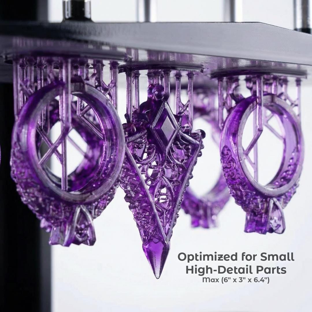 Purple resin printed jewelry components suspended on a build plate, showing intricate geometry, sharp edges, and fine internal structures. Small-format parts optimized for high-detail production with clean surfaces and precise features not achievable with standard filament printing.