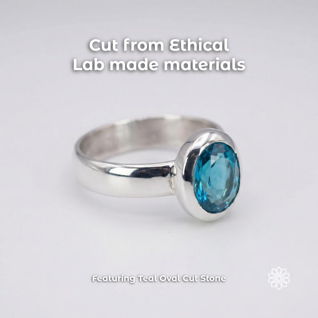 3ct oval cut teal sapphire ring in polished sterling silver bezel setting, displayed on clean white background. Lab-created sapphire with vivid blue-green tone and high clarity. Smooth silver band with low profile setting, highlighting stone shape, color, and reflective metal finish for detailed product view.