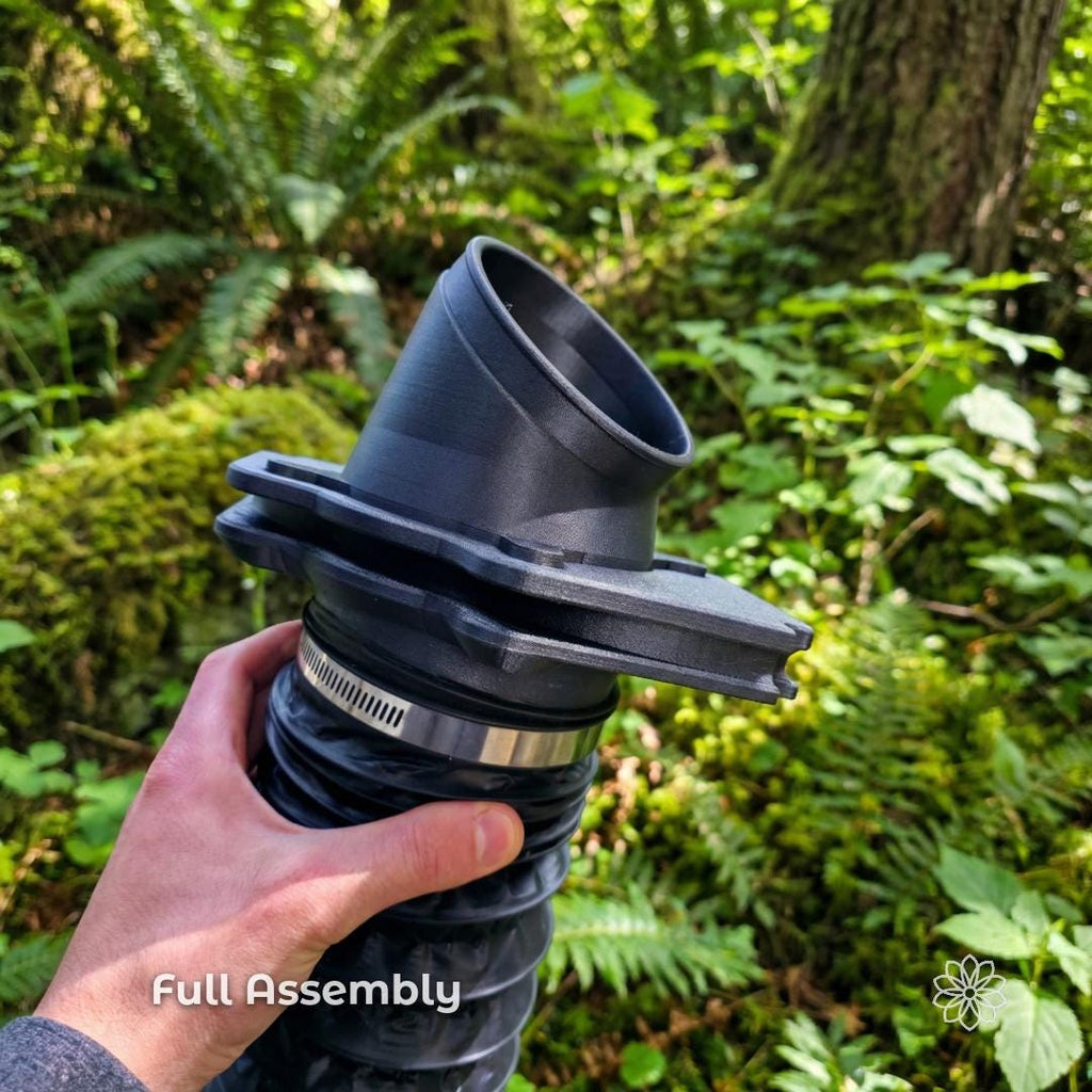 Full Tent Link heater port assembly held by hand with flexible duct attached, showing complete diesel heater airflow system with angled adapter and main housing, black carbon fiber composite components used for directing heat into rooftop or ground tents.