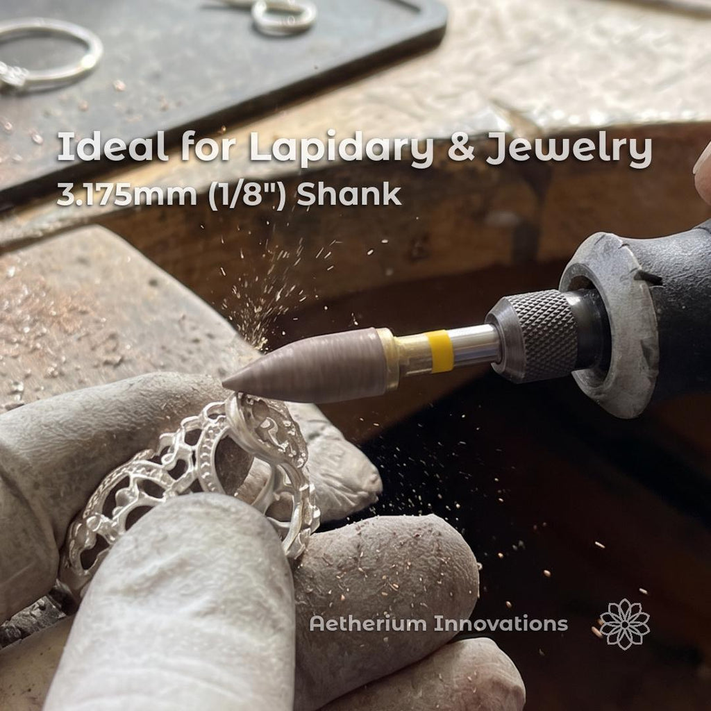 Hands wearing gloves use a rotary tool with a sintered diamond bur to shape a detailed metal ring at a jeweler’s bench, fine metal dust lifting from the contact point as the tool refines intricate surfaces with controlled precision.