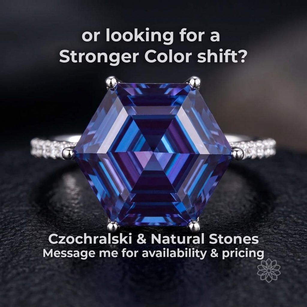 Hexagon-cut alexandrite gemstone ring displaying a strong blue to purple color shift, set in a silver band on a dark reflective surface. High-contrast lighting emphasizes sharp facet geometry and dramatic color change, representing premium Czochralski-grown and natural alexandrite for custom jewelry.