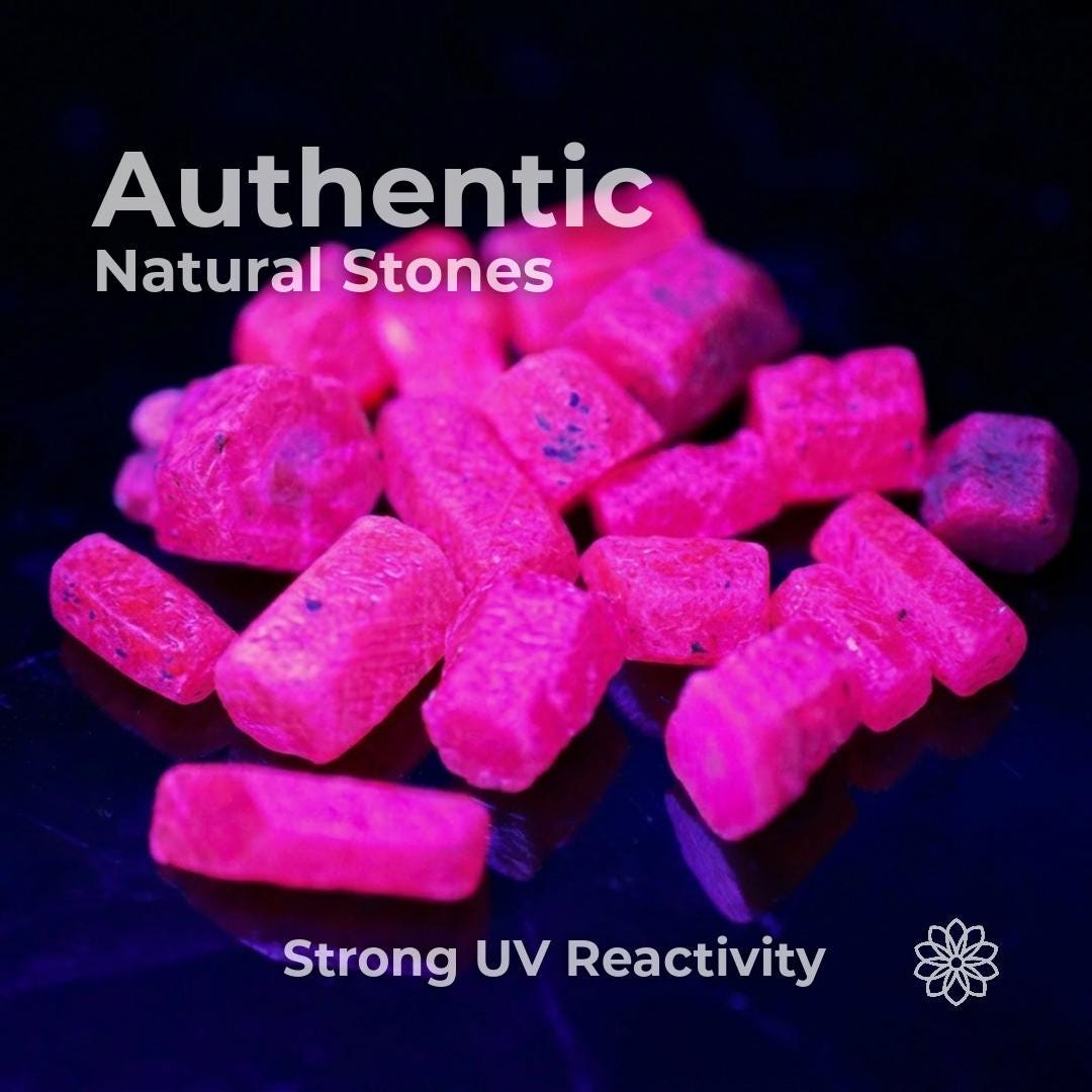 Natural pink Madagascar ruby and sapphire rough glowing bright pink under UV light against a dark background. Text reads “Authentic Natural Stones” and “Strong UV Reactivity,” showing fluorescence, surface texture, and natural inclusions useful for lapidary artists evaluating real corundum rough for cabbing, cutting, carving, or specimen work.