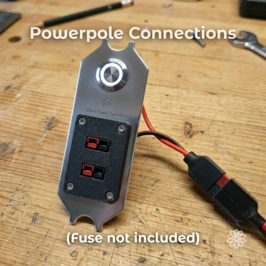 Text reads “Powerpole Connections” and “Fuse not included.” Daisy Power Systems DC switch panel shown on a wood bench with red and black wires leading to Anderson Powerpole connectors. The image explains the panel’s connection style for Super Pacific X1 camper power systems and clearly notes that the fuse is not included.