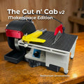 Cut n’ Cab V2 MakerSpace Edition compact modular maker workstation on a wood bench, shown with saw table, wet grinder housing, angle jig, and Aetherium Innovations branding for cutting, grinding, shaping, polishing, and small-part workshop fabrication.