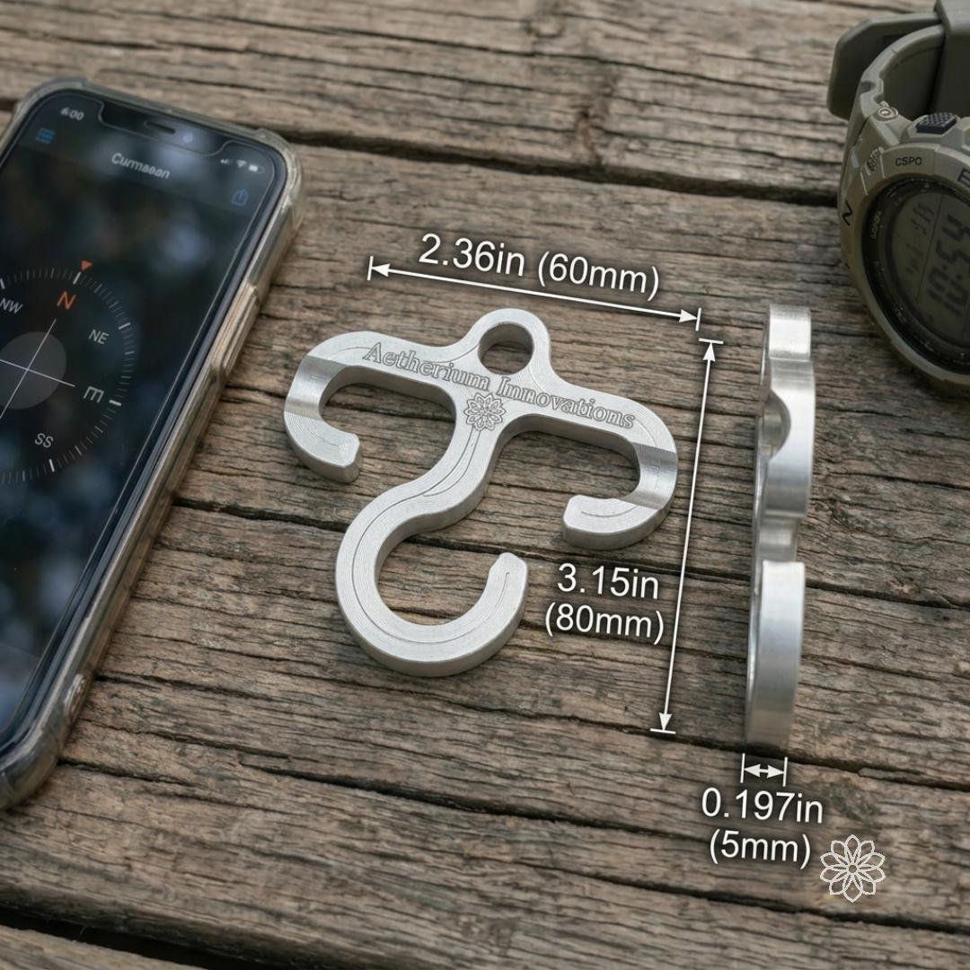 Size reference for the aluminum Paracord Hook Mini on weathered wood beside outdoor gear, showing dimensions of 2.36 inches wide, 3.15 inches tall, and 0.197 inches thick. Compact machined gear hook for EDC kits, paracord loops, backpacks, and lightweight camp organization.