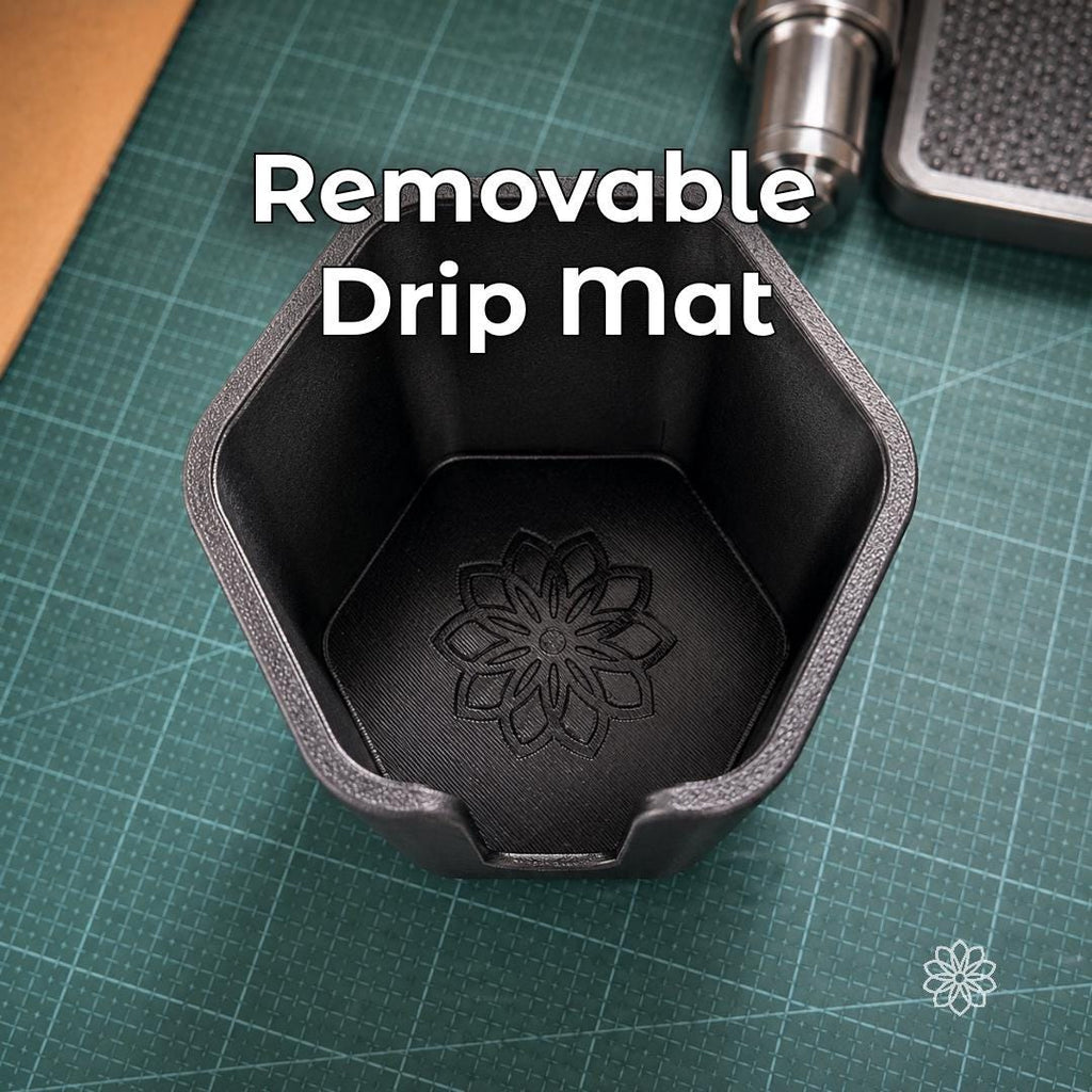 Top-down view inside the Jeep Nalgene cup holder adapter showing the removable drip mat with Aetherium flower mark, designed to catch moisture and make the holder easier to clean after daily or trail use.