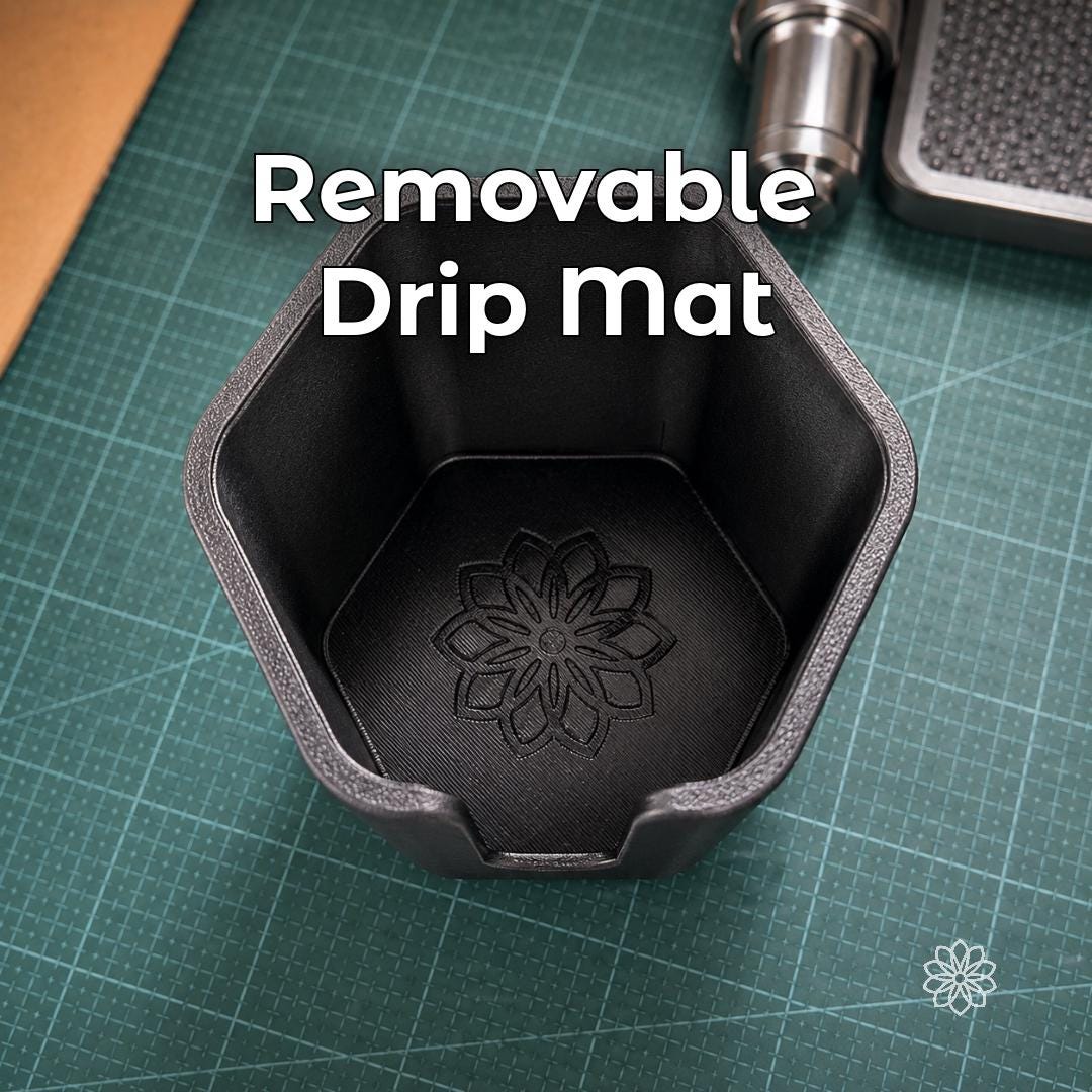 Top-down view inside the Jeep Nalgene cup holder adapter showing the removable drip mat with Aetherium flower mark, designed to catch moisture and make the holder easier to clean after daily or trail use.
