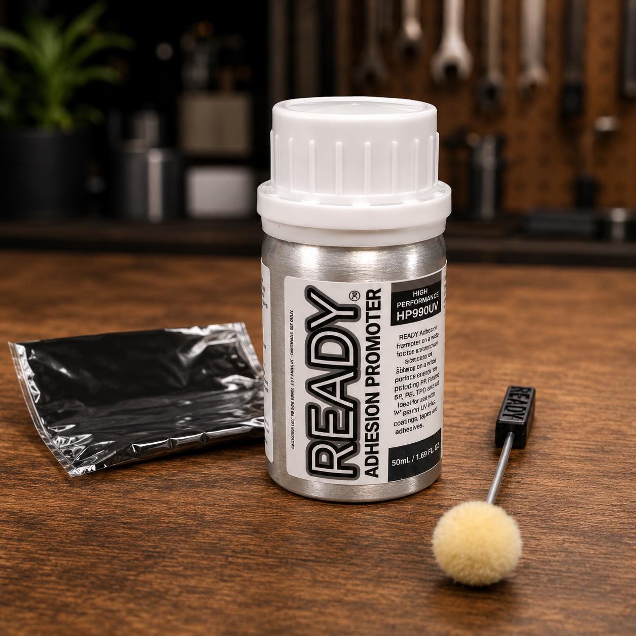 Plastic bonding primer and adhesion promoter kit featuring a 50ml bottle, surface preparation pad, and applicator dauber on a workshop bench. Surface primer designed to improve adhesive performance on difficult plastics including TPU, TPO, polypropylene, polyethylene, and other low surface energy materials. Used for tape adhesion, plastic bonding, adhesive-backed components, product assembly, fabrication, and maker projects where conventional adhesives struggle to achieve reliable bonds.