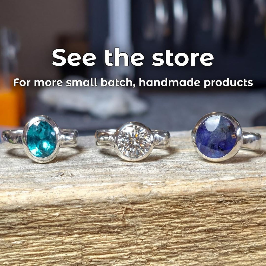 Three handmade gemstone rings displayed with text reading “See the store,” promoting Aetherium’s small-batch handmade jewelry alongside Rockhounder’s Salve.