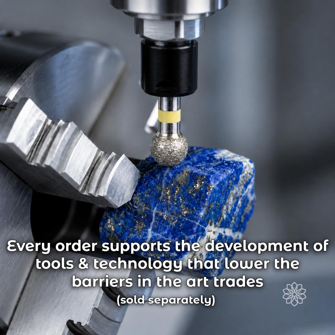 Sintered diamond ball bur machining rough lapis lazuli held in a CNC rotary chuck. Complementary gemstone carving tool for lapidary work, stone shaping, jewelry making, CNC machining, and pre-polish surface preparation.