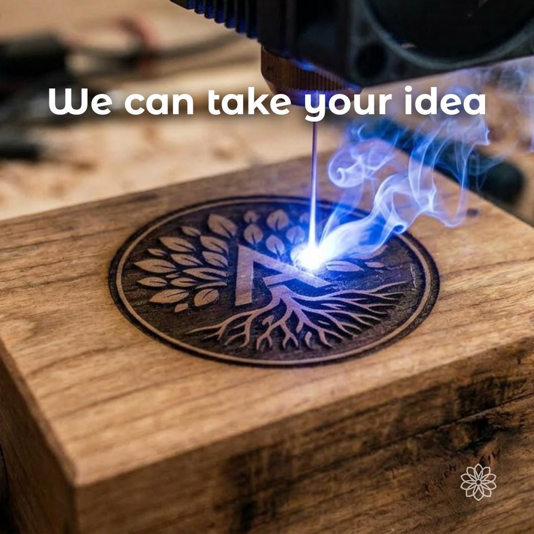 Laser engraving a circular tree-and-root emblem into a hardwood box lid as light and smoke rise from the surface. Overlay reads “We can take your idea,” showing the custom fabrication process behind branded corporate gifts, awards, and presentation experiences.