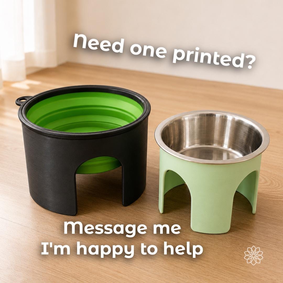 Two completed 3D-printed dog bowl risers displayed on a wood surface, including a large black stand holding a collapsible travel bowl and a smaller green stand holding a stainless-steel bowl. Custom printing assistance is available separately.