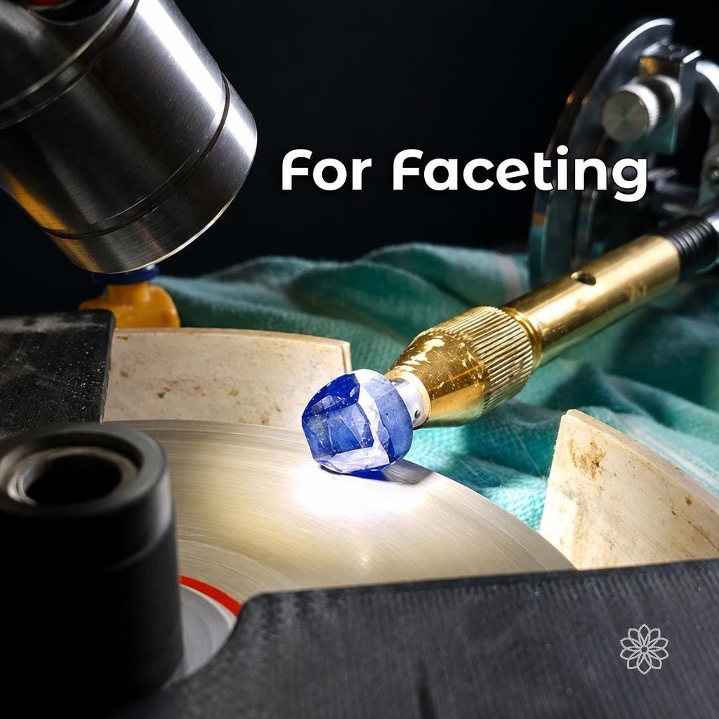 Blue faceted gemstone held on a transparent 6 mm polycarbonate dop in a brass faceting-machine quill above a rotating lap. The image shows the dop supporting a stone during precision gemstone cutting and polishing.