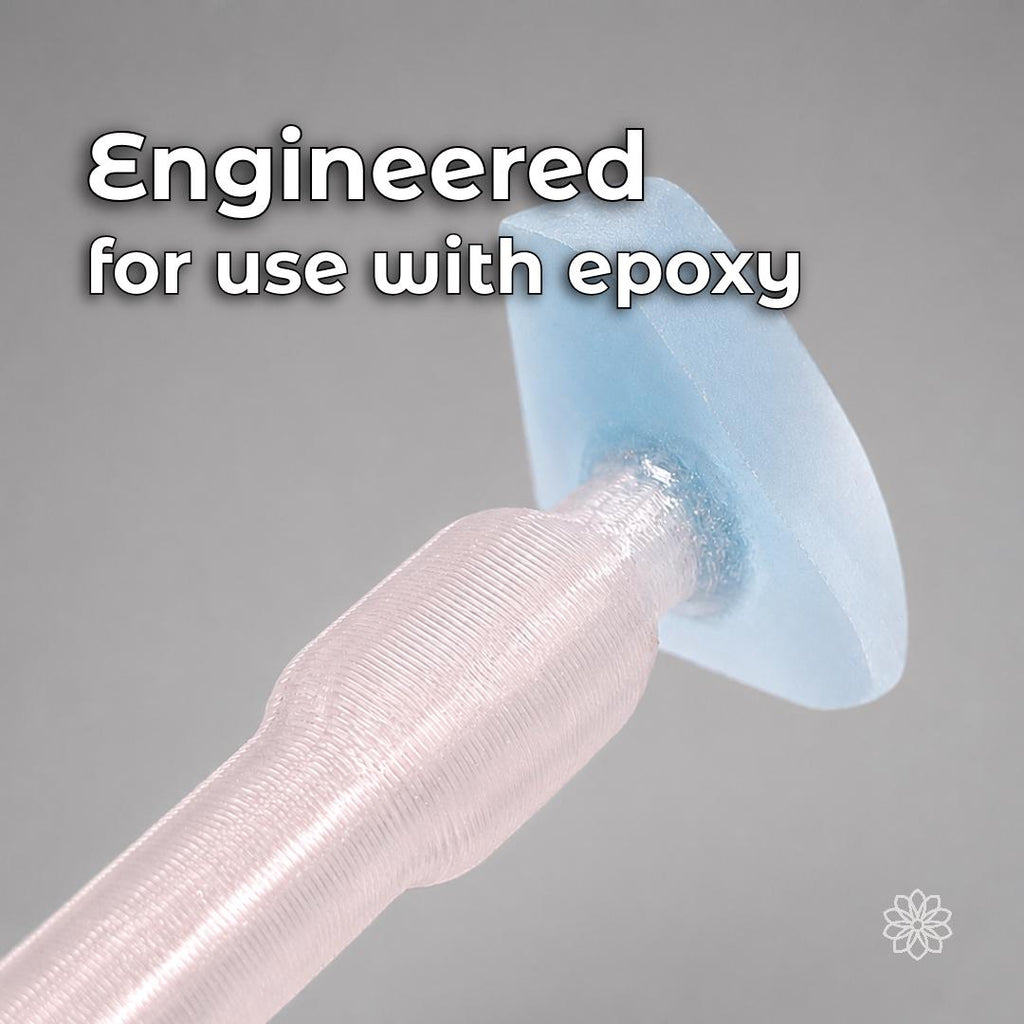 Macro view of a transparent polycarbonate dop bonded with blue epoxy to a pale blue gemstone preform. The image shows the Aetherium dop system designed for epoxy and compatible CA adhesive workflows instead of traditional heat-transfer wax dopping.