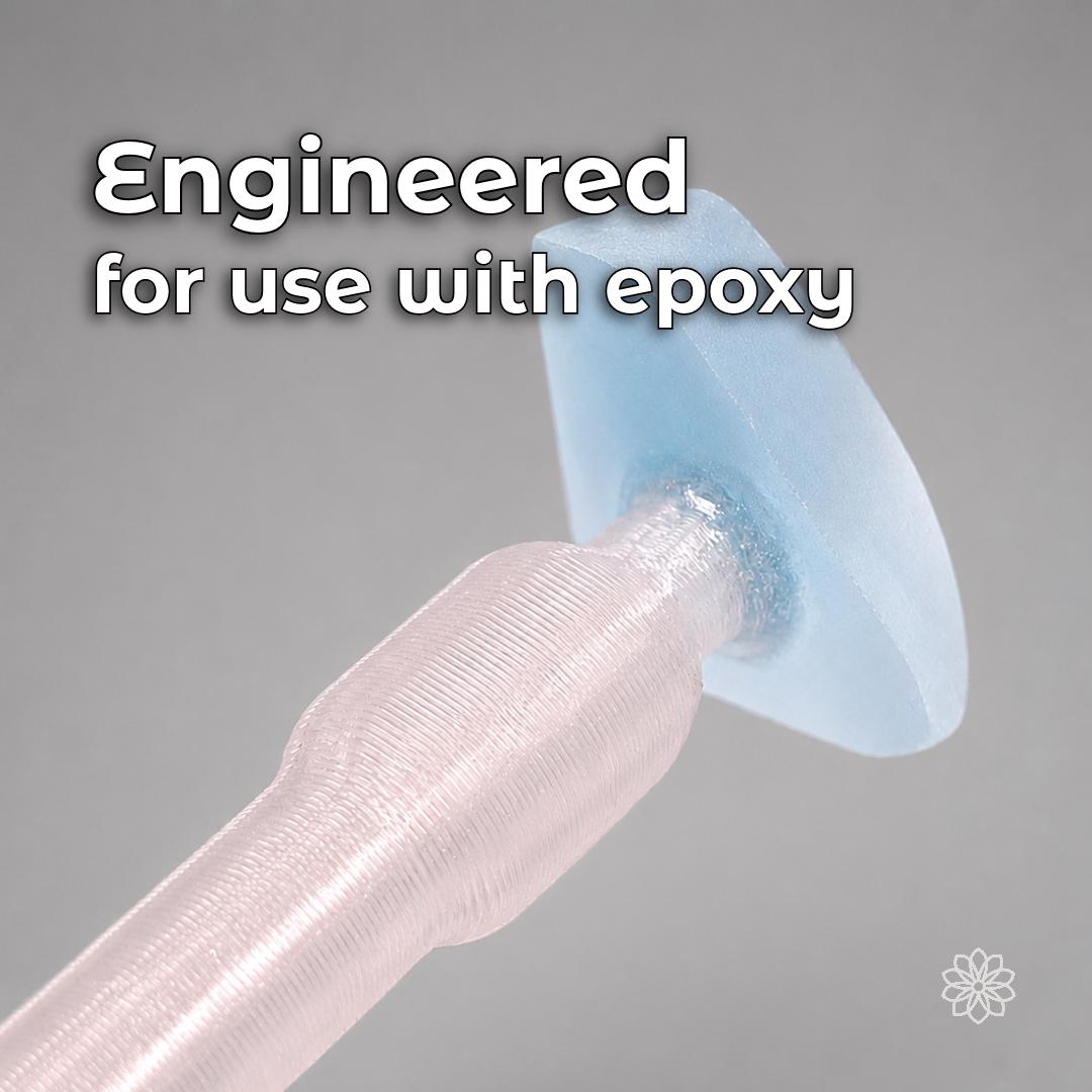 Macro view of a transparent polycarbonate dop bonded with blue epoxy to a pale blue gemstone preform. The image shows the Aetherium dop system designed for epoxy and compatible CA adhesive workflows instead of traditional heat-transfer wax dopping.