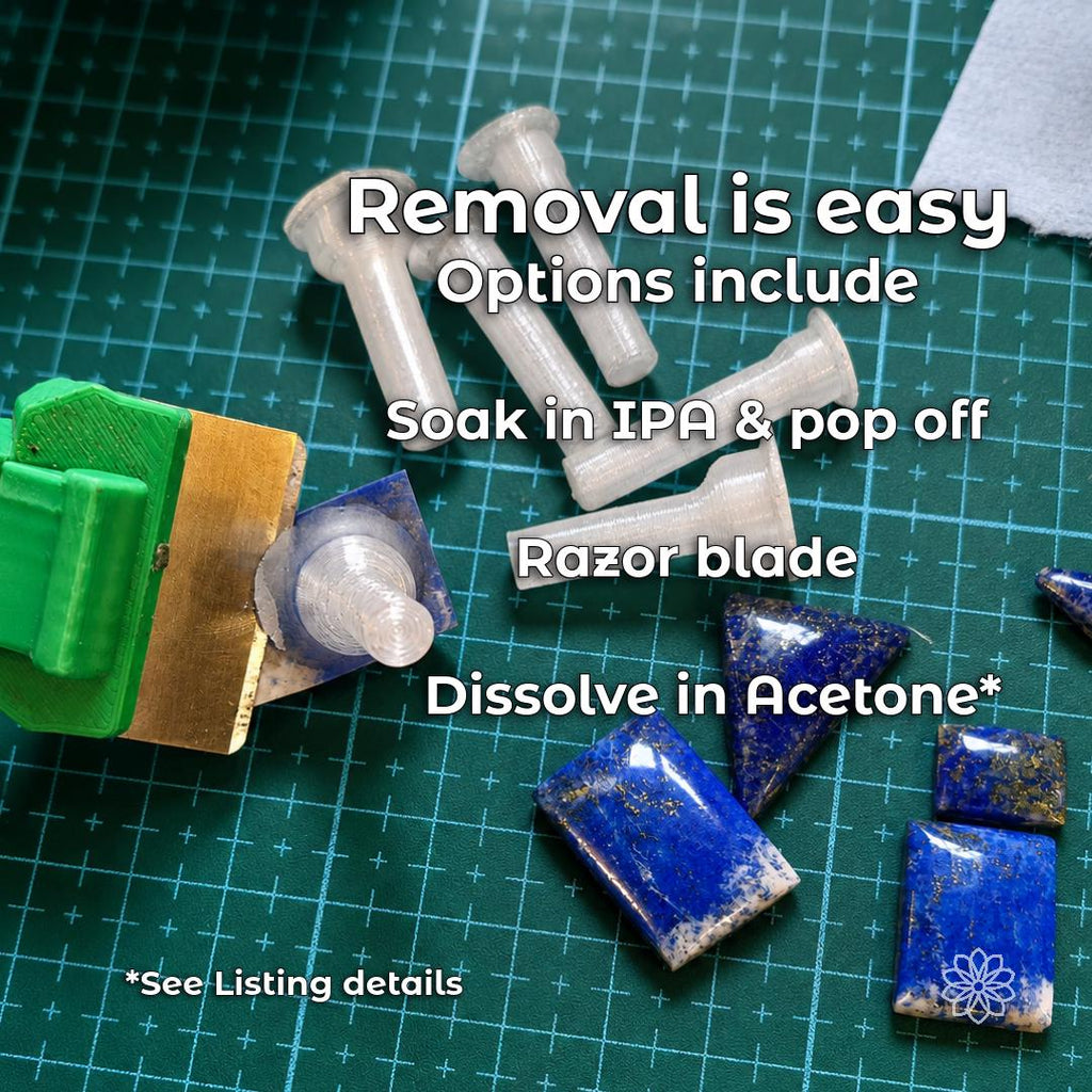 Lapidary workbench with transparent polycarbonate dops, blue stone preforms and polished cabochons. The image explains mechanical separation, adhesive-compatible IPA soaking and acetone dissolution of the dop as possible stone-removal methods.