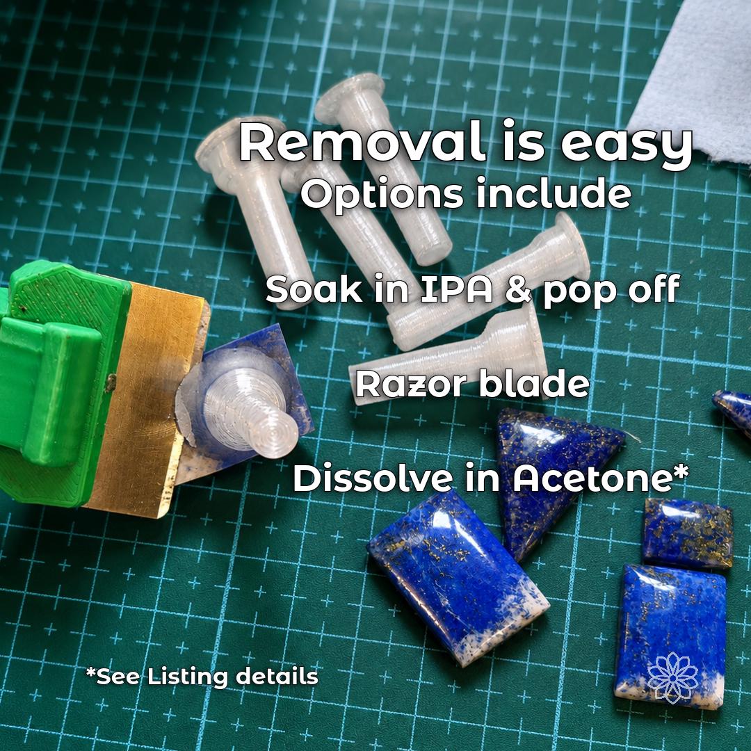 Lapidary workbench with transparent polycarbonate dops, blue stone preforms and polished cabochons. The image explains mechanical separation, adhesive-compatible IPA soaking and acetone dissolution of the dop as possible stone-removal methods.