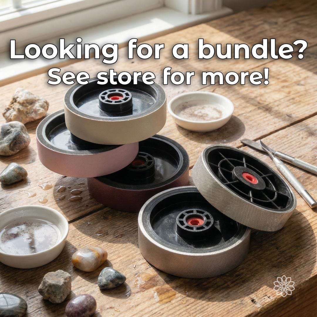 Multiple lapidary cabbing wheels arranged on a wet wooden workbench with rough stones, polished pebbles, water dishes, and hand tools. Text directs buyers looking for a full grinding and polishing sequence to the separate cabbing wheel bundle listing.