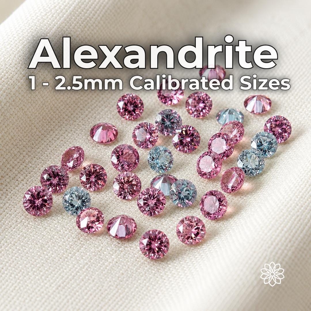 Round-cut lab-grown alexandrite gemstones in calibrated 1 mm to 2.5 mm sizes arranged on white fabric. Faceted stones show vivid pink, lavender, pale blue and green color shifts under changing light. Loose alexandrite stones for jewelry making, pavé settings, halo accents, side stones and precision inlay.