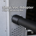 Makera Carvera Air shop-vac adapter with black 3D-printed construction, installed between the desktop CNC machine's rear dust port and a vacuum hose for external chip and dust collection.