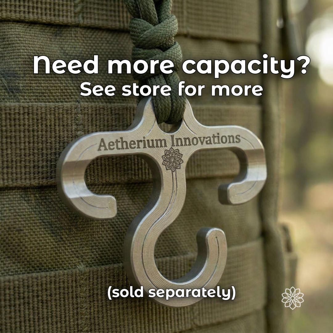 Machined aluminum Aetherium Innovations gear hanger attached to olive paracord on a tactical backpack. Heavy-duty outdoor hook designed for carrying and organizing larger camp, hiking, overlanding, and field gear. Close-up product image shows the CNC-machined metal construction, integrated attachment loop, and dual hook geometry.