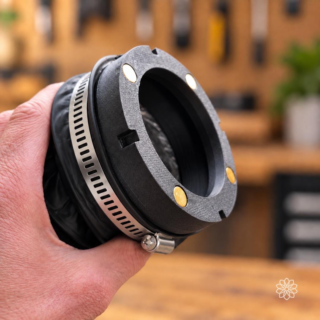 Close-up of the hose-side Mag-Link magnetic diesel heater coupler attached to flexible 4 inch ducting with a stainless hose clamp. Embedded magnets and alignment features form the quick-connect interface for repeated setup and teardown.
