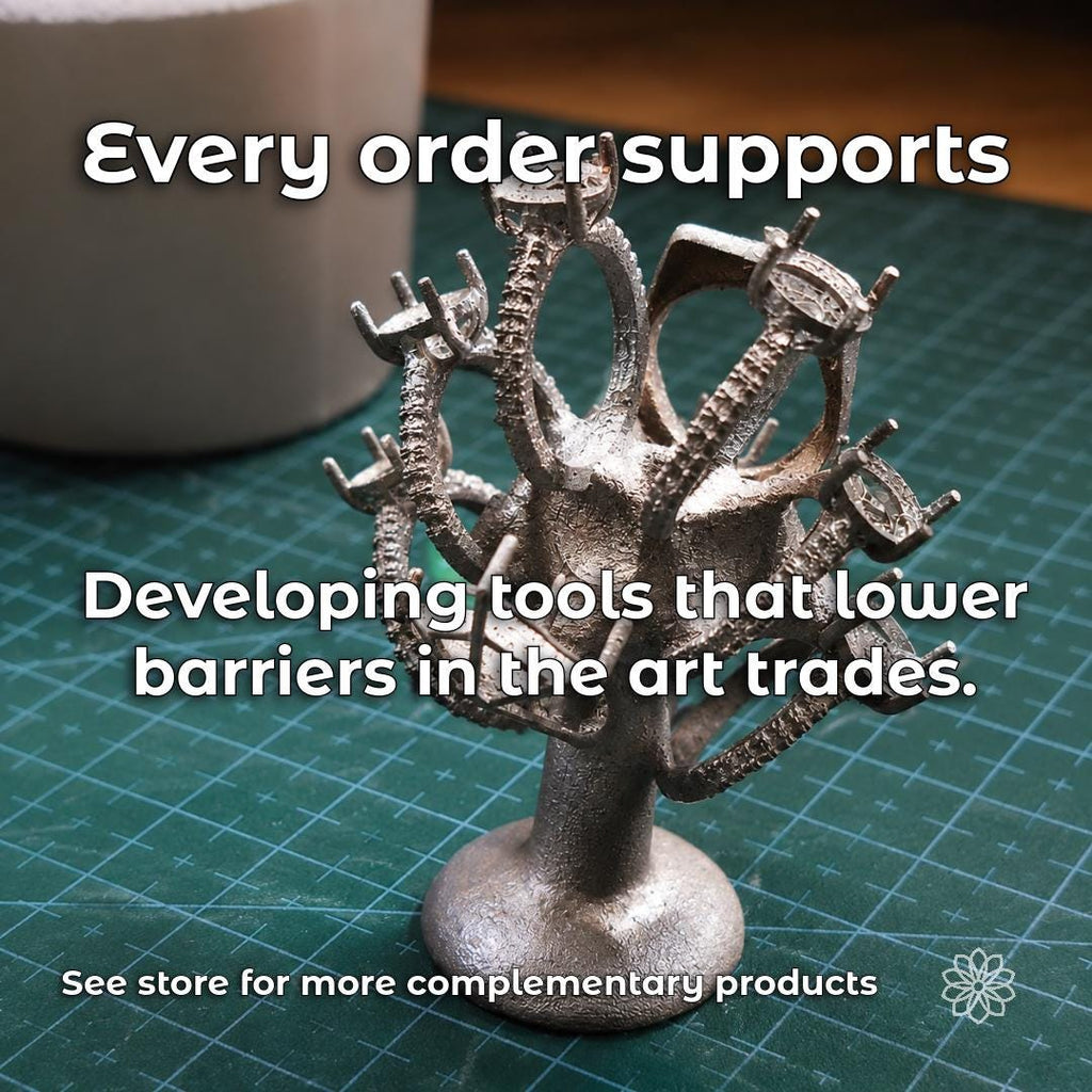 Tree-shaped jewelry casting on a cutting mat with text describing Aetherium’s mission to develop tools that lower barriers in the art trades.