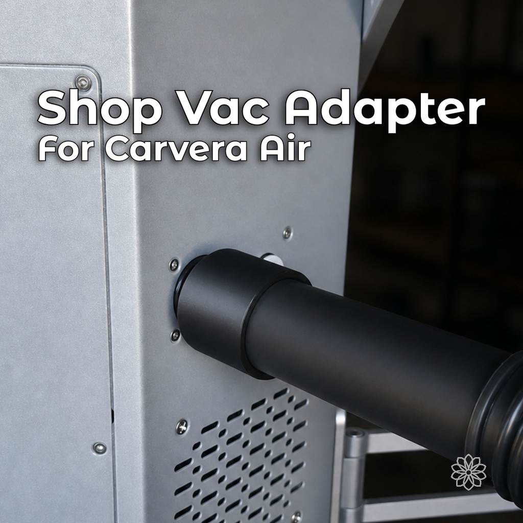 Makera Carvera Air shop-vac adapter with black 3D-printed construction, installed between the desktop CNC machine's rear dust port and a vacuum hose for external chip and dust collection.